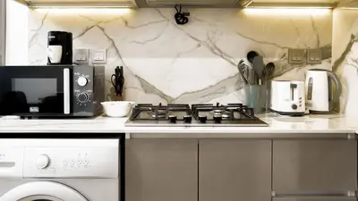 a kitchen with a stove and a microwave at Azizi Riviera 1, Meydan Close to Downtown - Onelink in Dubai