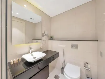 a bathroom with a sink and a toilet and a mirror at NEW Noma Majestine Hotel Style Apt Business Bay in Dubai