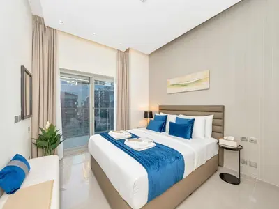 a bedroom with a large bed with blue pillows at NEW Noma Majestine Hotel Style Apt Business Bay in Dubai