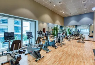 a gym with a bunch of treadmills and ellipticals at Marina Sea View Room Dubai in Dubai