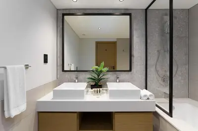 a bathroom with two sinks and a large mirror at Maison Privee - Tranquil Living with Golf Course Vws in Dubai Hills in Dubai
