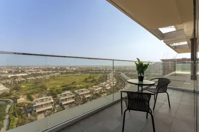a balcony with a table and chairs and a view of a city at Maison Privee - Tranquil Living with Golf Course Vws in Dubai Hills in Dubai