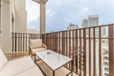a balcony with a couch and a coffee table at Elegant 1BR, Easy Access to Creek Harbour Night Vision - Summer at Creek Beach Building 3 by Deluxe Holiday Homes in Dubai
