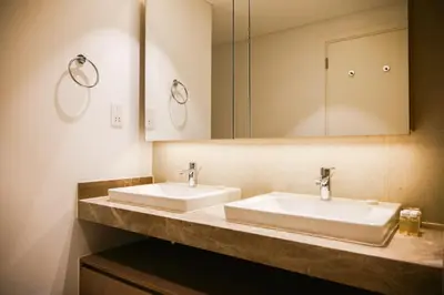 a bathroom with two sinks and a mirror at HAVN - High Floor 2 bedroom in The Grand in Dubai