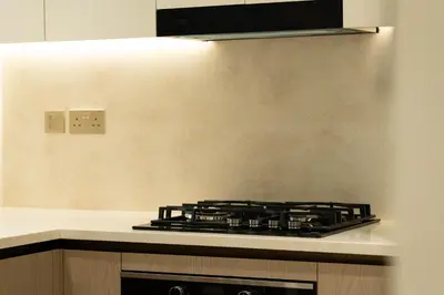 a stove top oven in a kitchen next to a wall at Luxury Apartment with Private Pool & Gym in Dubai