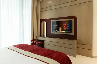 a bedroom with a bed and a tv on a wall at Luxury Apartment with Private Pool & Gym in Dubai