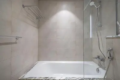 a bathroom with a shower and a bath tub at Famous Sky Pool at Paramount's King's 2BR in Dubai