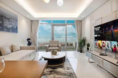 a living room with a couch and a large window at Famous Sky Pool at Paramount's King's 2BR in Dubai