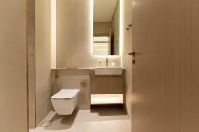 a bathroom with a white toilet and a sink at Designer Apartment with Private Pool in Dubai