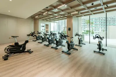 a gym with a row of exercise bikes in a room at Designer Apartment with Private Pool in Dubai