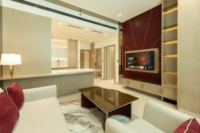 a living room with a couch and a tv at Designer Apartment with Private Pool in Dubai