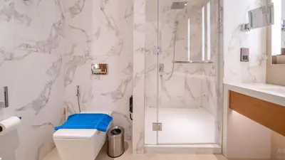 a white bathroom with a shower and a toilet at Prestige 3Bed with Full Iconic Burj Khalifa Views in Dubai
