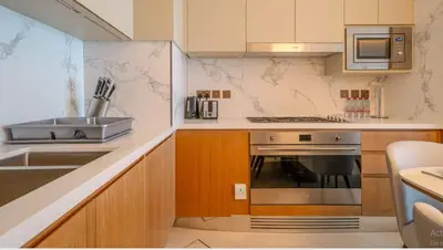a kitchen with a sink and a stove top oven at Prestige 3Bed with Full Iconic Burj Khalifa Views in Dubai