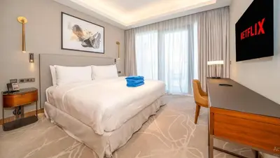 a hotel room with a large bed and a desk at Prestige 3Bed with Full Iconic Burj Khalifa Views in Dubai