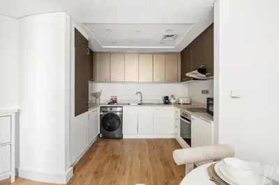 a kitchen with white cabinets and a dishwasher at Luxury High-Floor Suite Museum of the Future View in Dubai