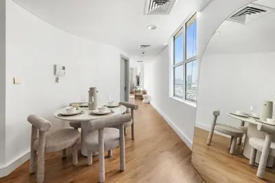 a dining room with a table and chairs and a window at Luxury High-Floor Suite Museum of the Future View in Dubai