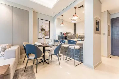a dining room and living room with a table and chairs at High-Floor 2BR with Vibrant Street Views and Effortless Drive Access to Downtown Hotspots, Nobles Tower, Business Bay by Deluxe Holiday Homes in Dubai