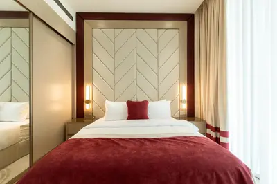 a bedroom with a large bed with a red blanket at Modern Apartment with Private Balcony Pool in Dubai