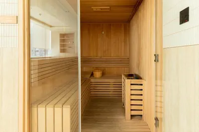 a sauna with wood paneling and a wooden floor at Luxury Apartment with Private Pool in JVC in Dubai