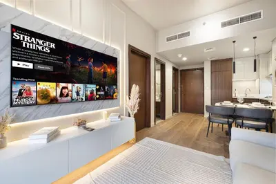a living room with a large tv hanging on a wall at Designer 2BR with Burj View 5 Min to Dubai Mall in Dubai