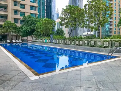 a large blue swimming pool in a city at Elegant studio balcony boulevard view in Dubai