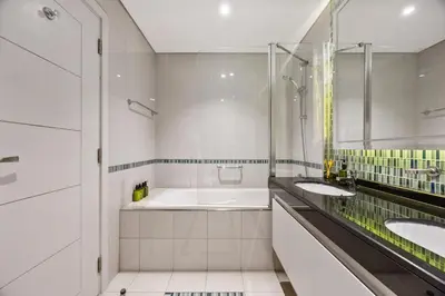 a white bathroom with two sinks and a tub at Elite Escapes - Glamorous Damac Heights - 2 BR in Dubai
