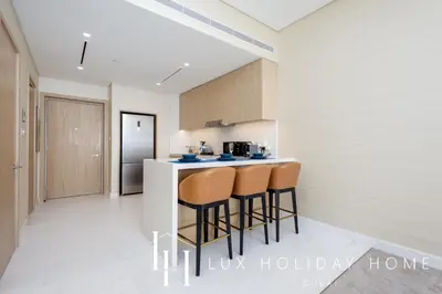 a kitchen with a counter and stools in a room at LUX Iconic Views at The Palm Tower Suite 7 in Dubai