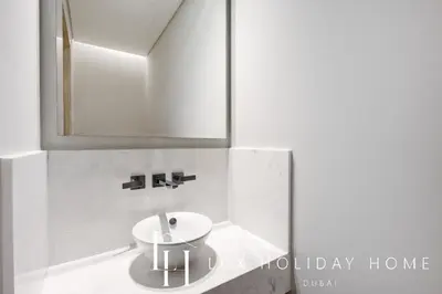 a bathroom with a white sink and a mirror at LUX Iconic Views at The Palm Tower Suite 7 in Dubai
