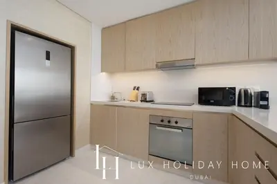 a kitchen with a stainless steel refrigerator and a microwave at LUX Iconic Views at The Palm Tower Suite 7 in Dubai