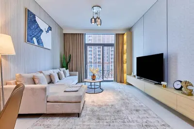 a living room with a couch and a flat screen tv at Premium 2BR Residence in Downtown Dubai in Dubai