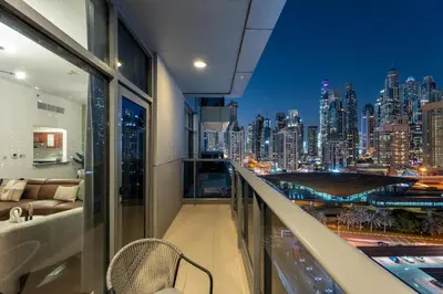 a balcony with a view of a city at night at GuestReady - 1BR | JLT Apt near Metro Station in Dubai
