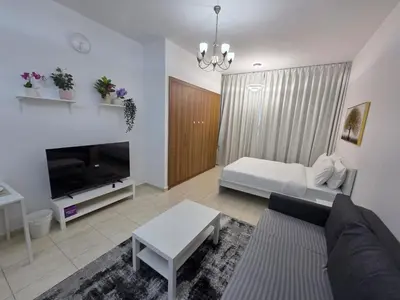 a living room with a couch and a fireplace at Skycourts - Well furnished Studio apartment in Dubai