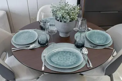a wooden table with plates and wine glasses on it at Modern Chic 1BHK Nobles Tower by Czechin in Dubai