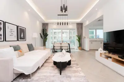 a living room with a white couch and a table at Gala Guests - Classic Opal Tower Suites Dubai Marina in Dubai