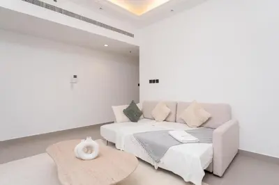 a white room with a bed and a couch at Gala Guests - Classic Opal Tower Suites Dubai Marina in Dubai
