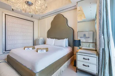 a bedroom with a large bed and a chandelier at Chic Central Downtown Home with Burj View in Dubai