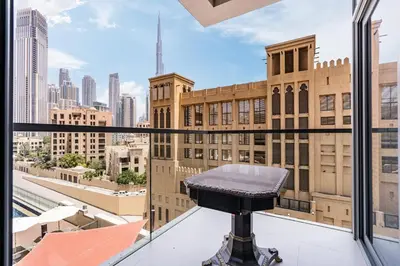 a stool on a balcony with a view of the city at Chic Central Downtown Home with Burj View in Dubai