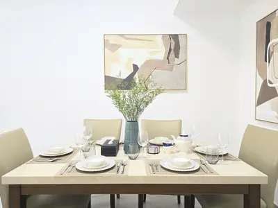 a dining room table with chairs and a vase with flowers at Marina Breeze - Serene Yacht Views near Ain Dubai 3 BR Apartment in Dubai