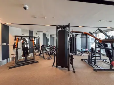 a gym with a lot of equipment in a room at Stylish 1BHK Retreat at Nobles Tower, by Czechin in Dubai