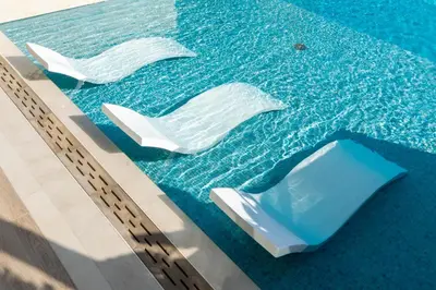 a swimming pool with two white chairs in the water at Exclusive Luxury Apartment with Private Pool in Dubai