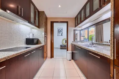 a large kitchen with two sinks and a hallway at Greenview 2BHK Stay in Dubai