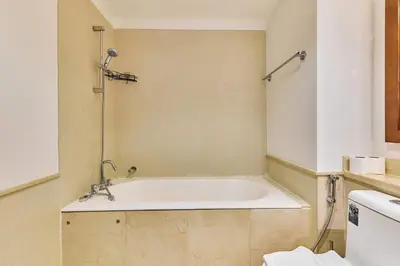 a bath tub in a bathroom with a toilet at Greenview 2BHK Stay in Dubai
