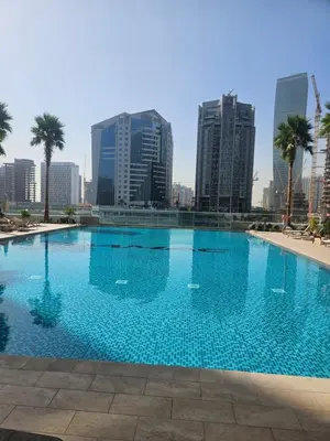 a large swimming pool in a city with tall buildings at Stunning Canal View Studio Business Bay in Dubai