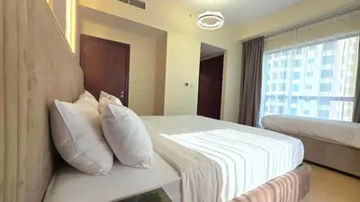 a hotel room with a bed with pillows and a window at Elan Rimal Bahar Suites, 1min walk to the Sea! Prime location JBR Beach Front in Dubai
