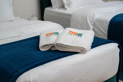 two towels are sitting on top of two beds at Luxury 3BR in Mada Residences - Walk to Dubai Mall in Dubai