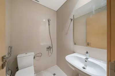 a bathroom with a toilet and a sink and a mirror at Luxury 3BR in Mada Residences - Walk to Dubai Mall in Dubai