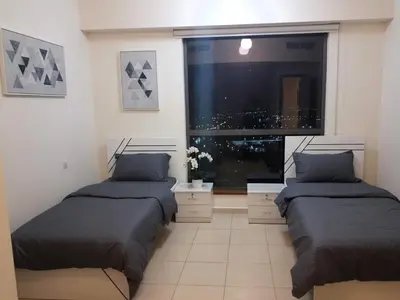 two beds in a room with a large window at Festive Winter Stay in JBR - Beach, Marina, Metro in Dubai