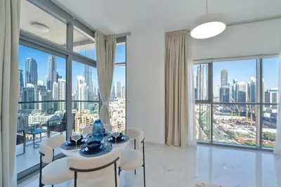 a dining room with a view of the city at Marcopolo - Signature High-Floor Apartment Facing Burj Khalifa in Sabkhah