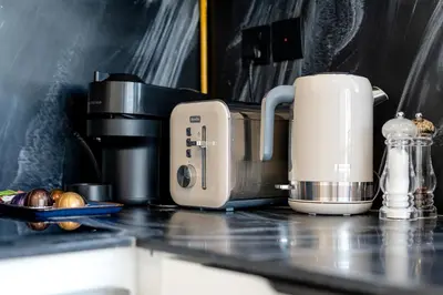 a toaster and coffee maker on a kitchen counter at Marcopolo - Signature High-Floor Apartment Facing Burj Khalifa in Sabkhah