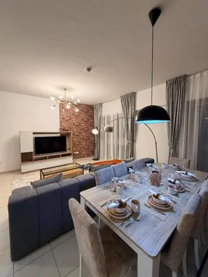 a living room with a table and a blue couch at Capital Stay - 2 Bed Apt in Business Bay in Dubai